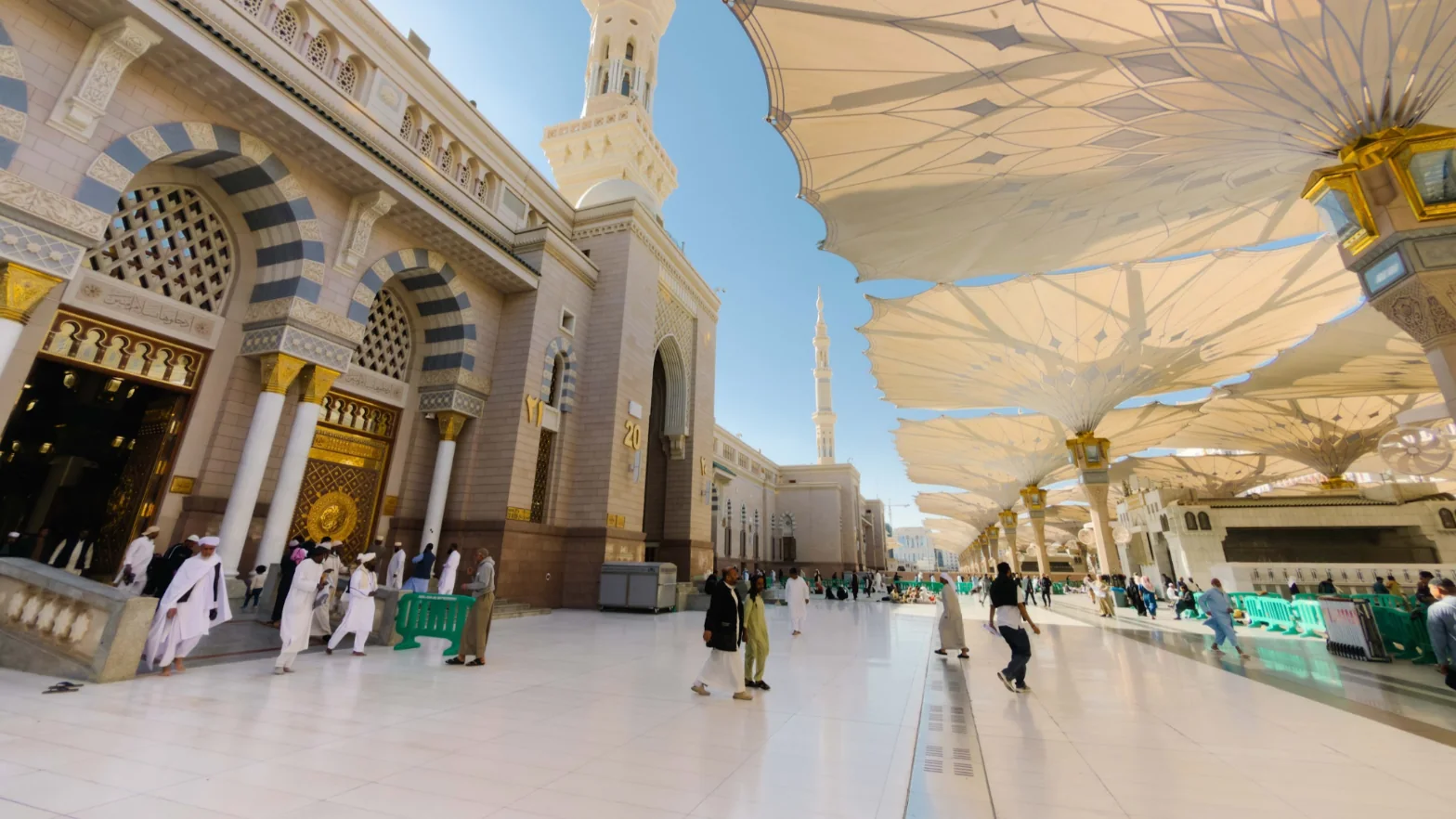 Jemaah berjalan di dataran berhampiran Pintu 20 Masjid Nabawi di bawah payung gergasi
