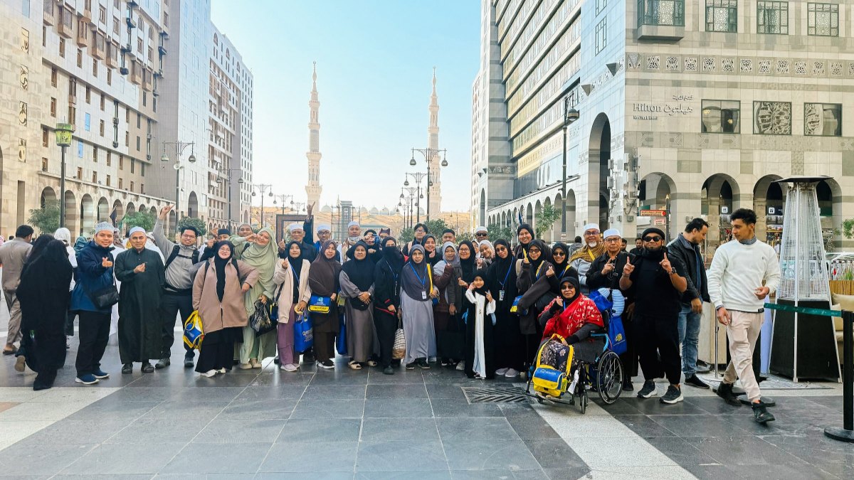 Rombongan jemaah MK Haramain bersama kru AkuIslam di Madinah dengan menara Masjid Nabawi di belakang