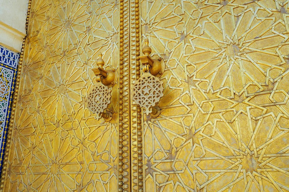 Ukiran geometri dan pengetuk pintu gangsa berlapis emas di istana diraja Fez