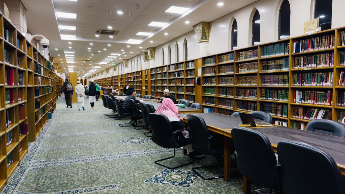 Rak kitab dan meja bacaan di sebuah ruang perpustakaan di Madinah