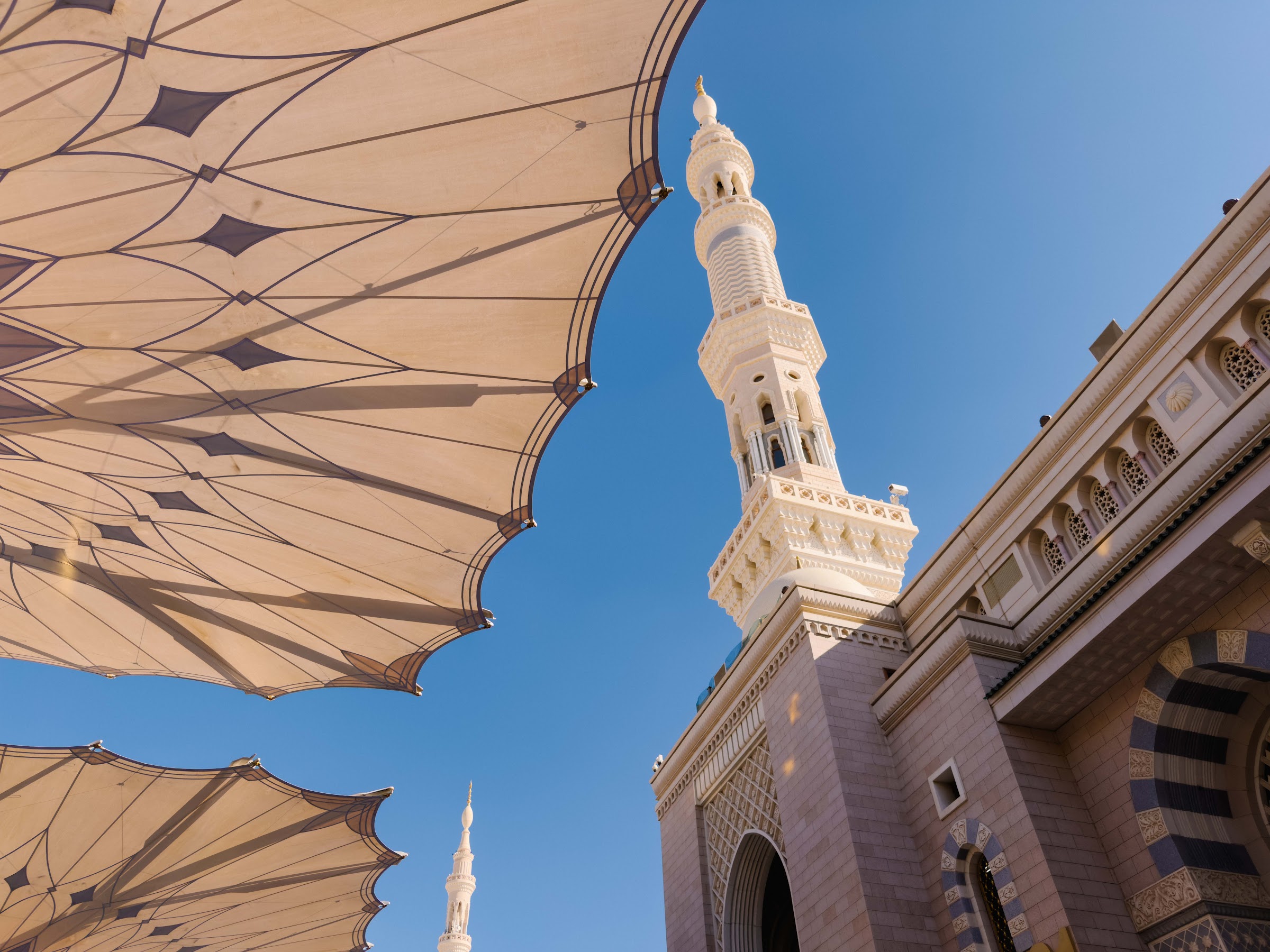 Menara Masjid Nabawi dilihat dari bawah payung gergasi di dataran masjid