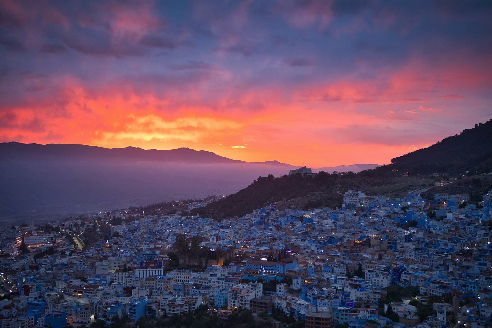 Langit senja berwarna jingga di atas Chefchaouen dan Banjaran Rif