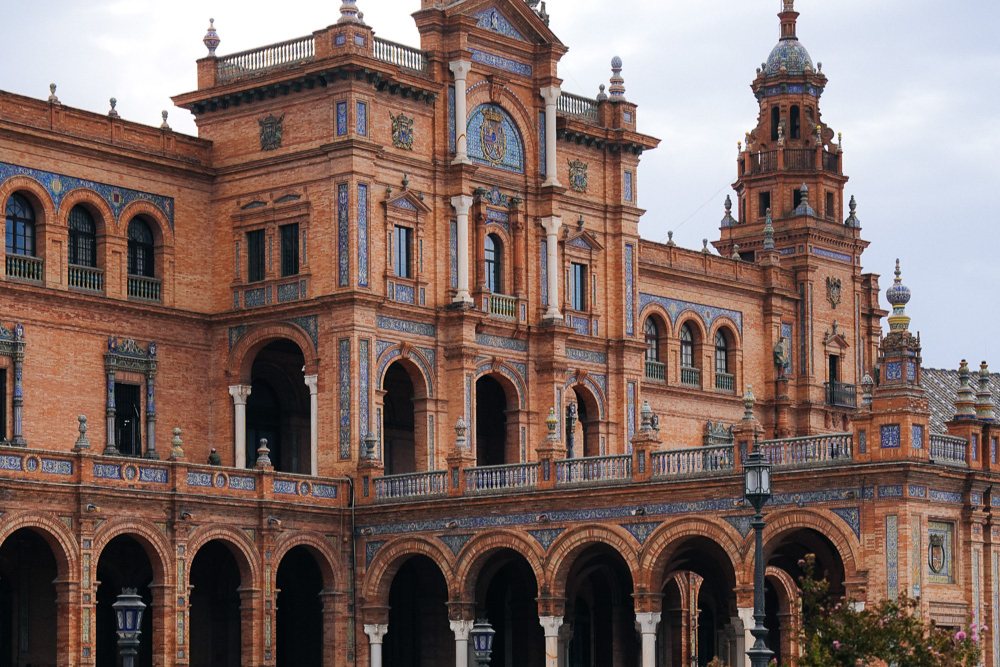 Bangunan tengah Plaza de España dan bot di kanal, Sevilla