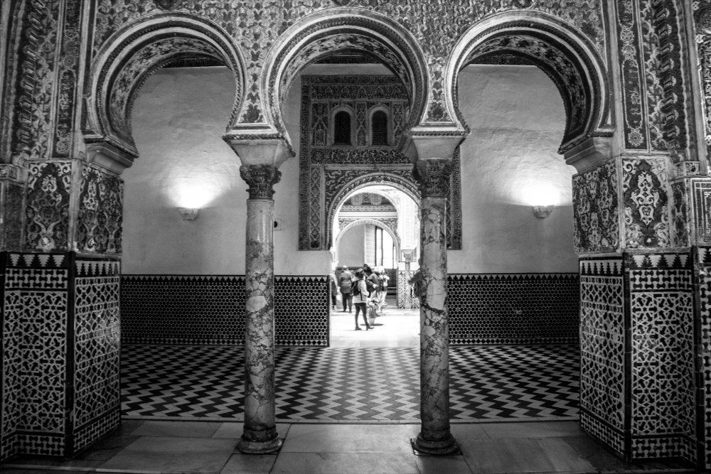 Gerbang berukir dan dinding jubin di dalam Real Alcázar Sevilla