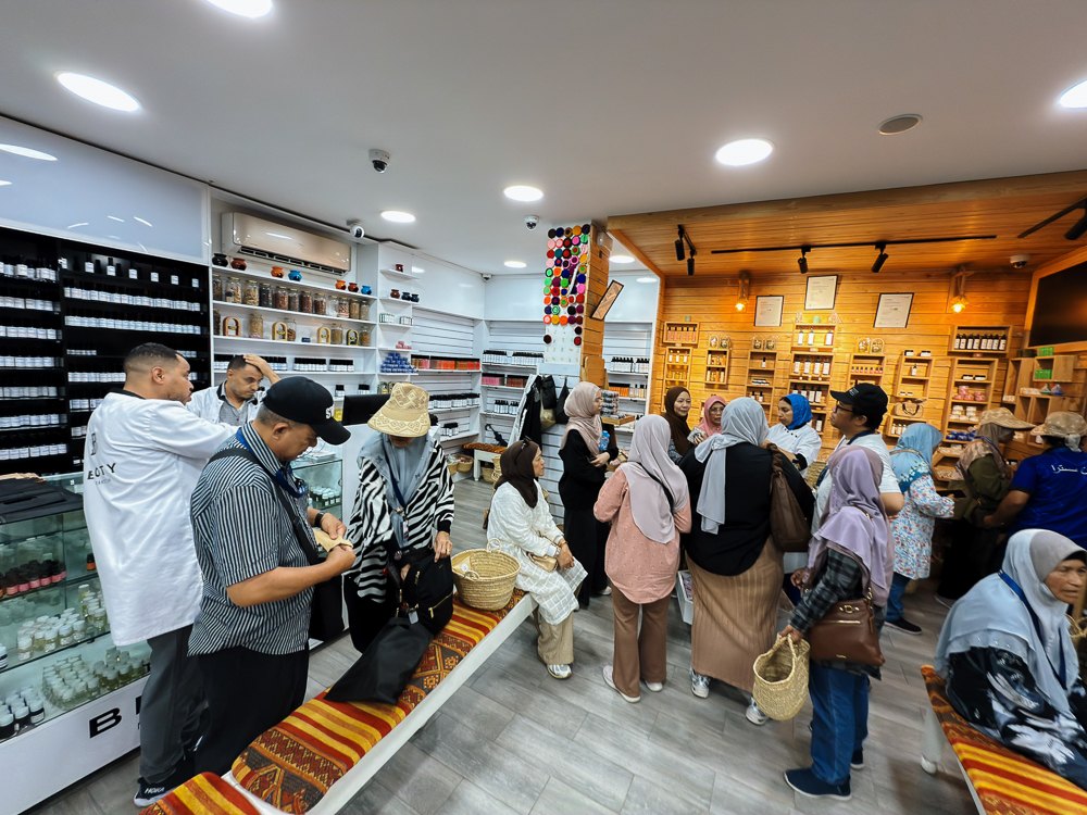 Rak balang rempah dan herba di dalam Spice Pharmacy Marrakech dengan pelawat rombongan
