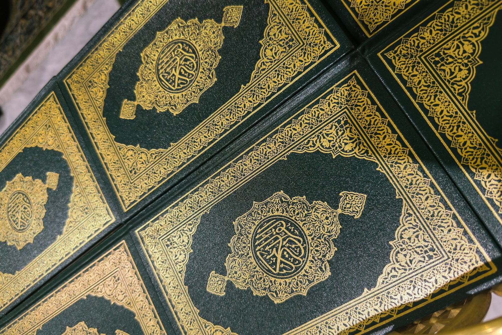 Deretan mushaf al-Quran berkulit hijau dan emas di rak Masjidil Haram