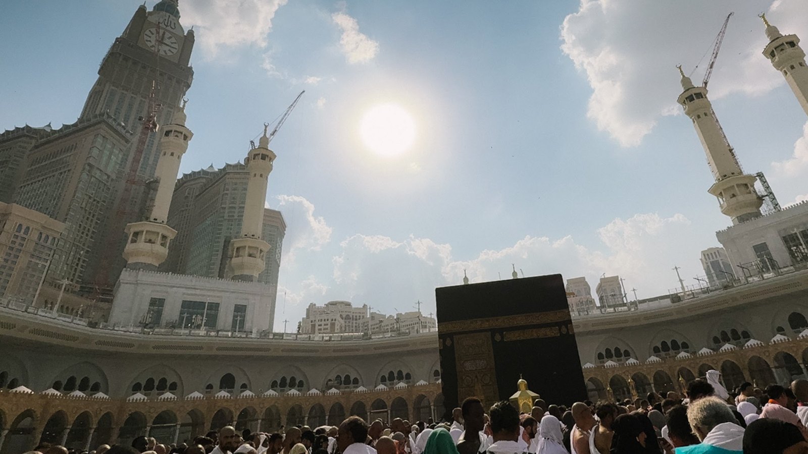 Jemaah di dataran tawaf mengelilingi Kaabah di Masjidil Haram dengan menara masjid di latar belakang