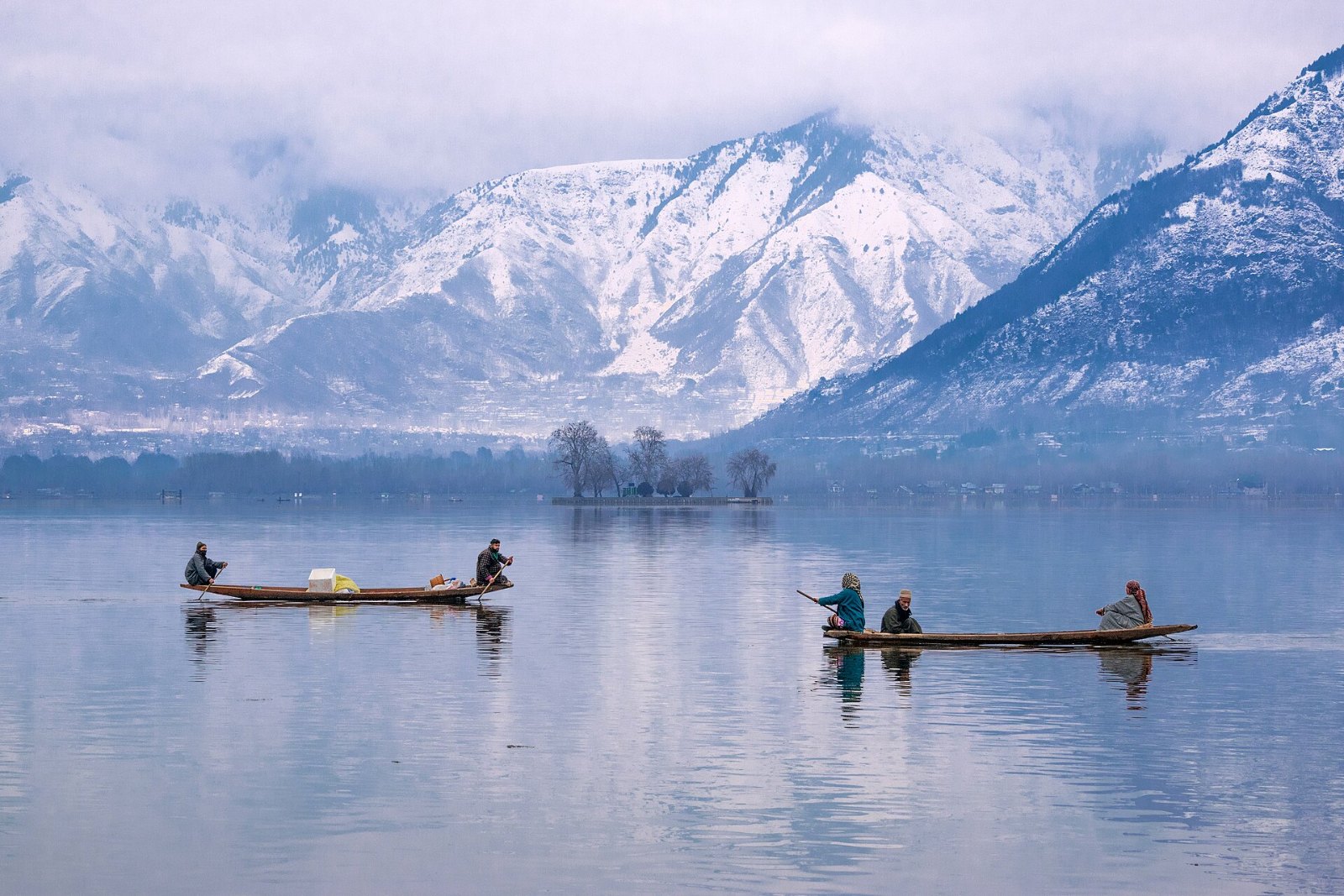 Shikara di Tasik Dal dengan banjaran bersalji, Srinagar
