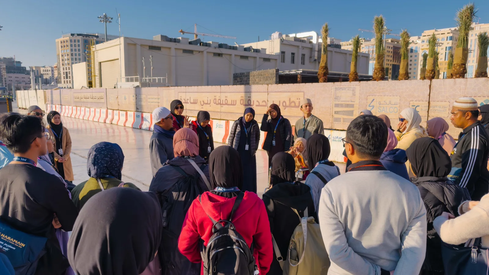 Mutawwif memberi penerangan kepada rombongan di hadapan dinding projek Taman Saqifah Bani Sa‘idah, Madinah
