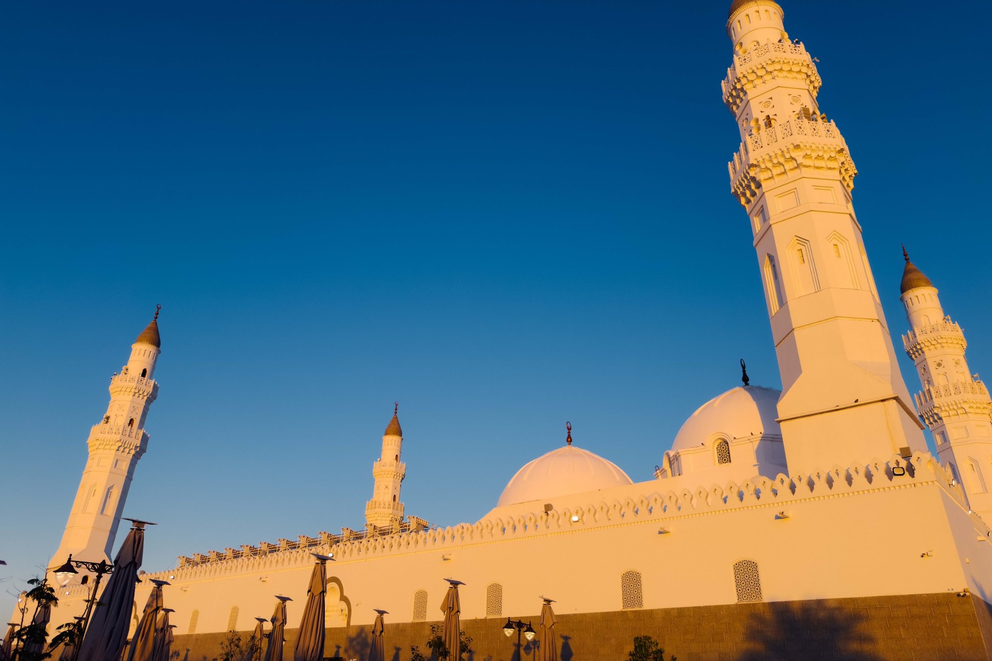 Masjid Quba di Madinah dengan menara dan kubah putih disinari cahaya petang