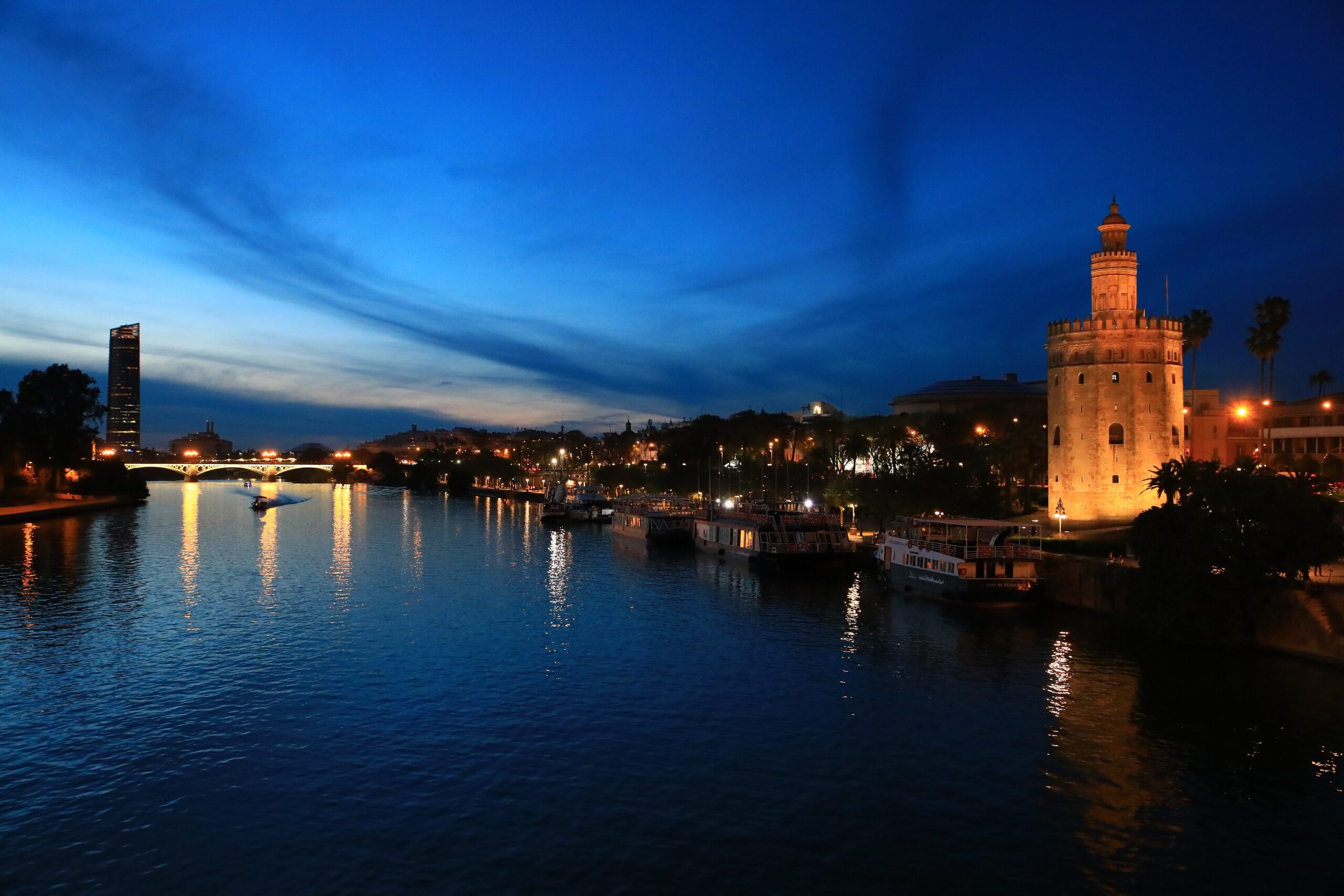 Torre del Oro dan Sungai Guadalquivir ketika senja dengan lampu kota