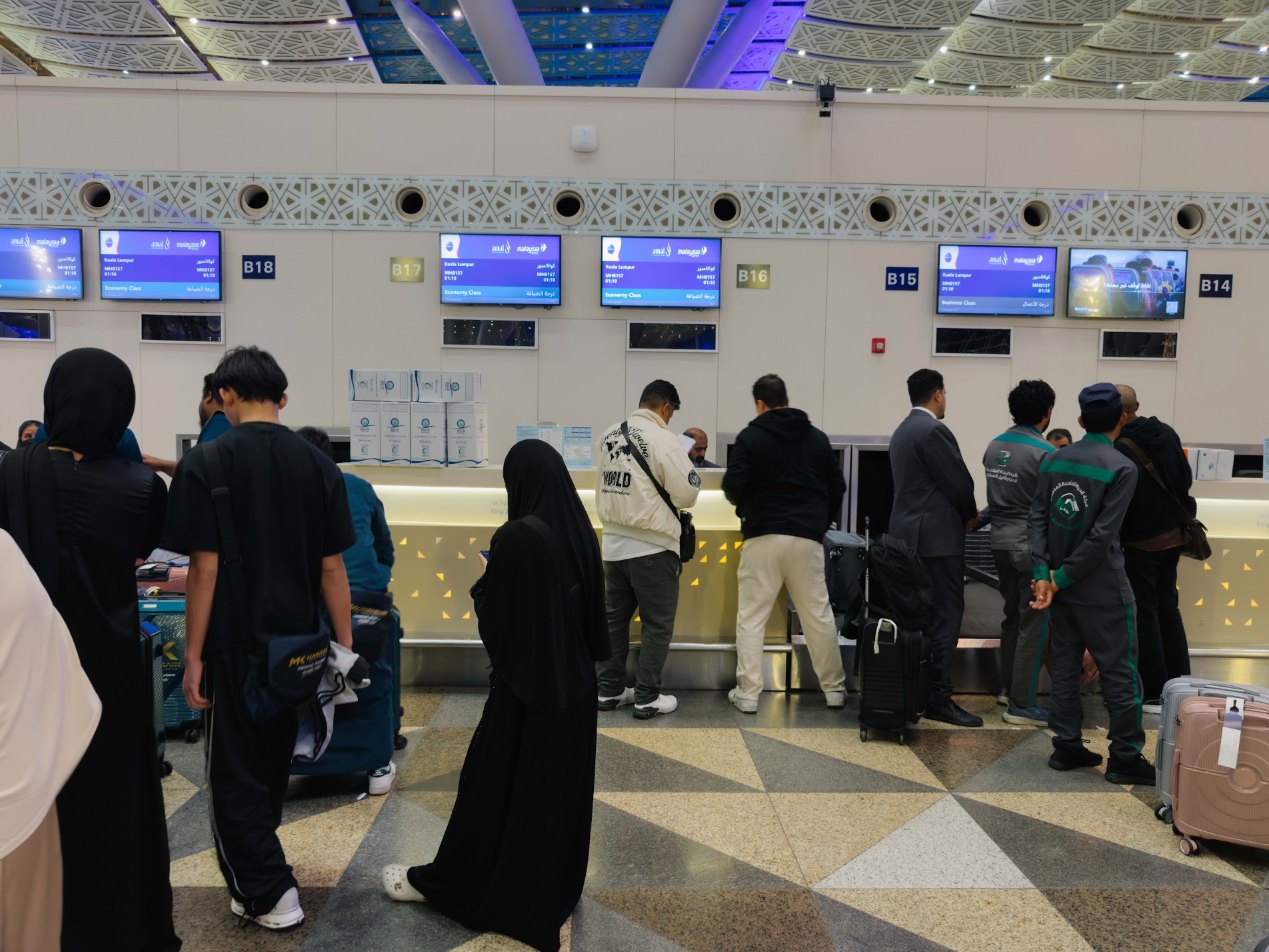 Jemaah umrah wanita di kaunter daftar masuk lapangan terbang