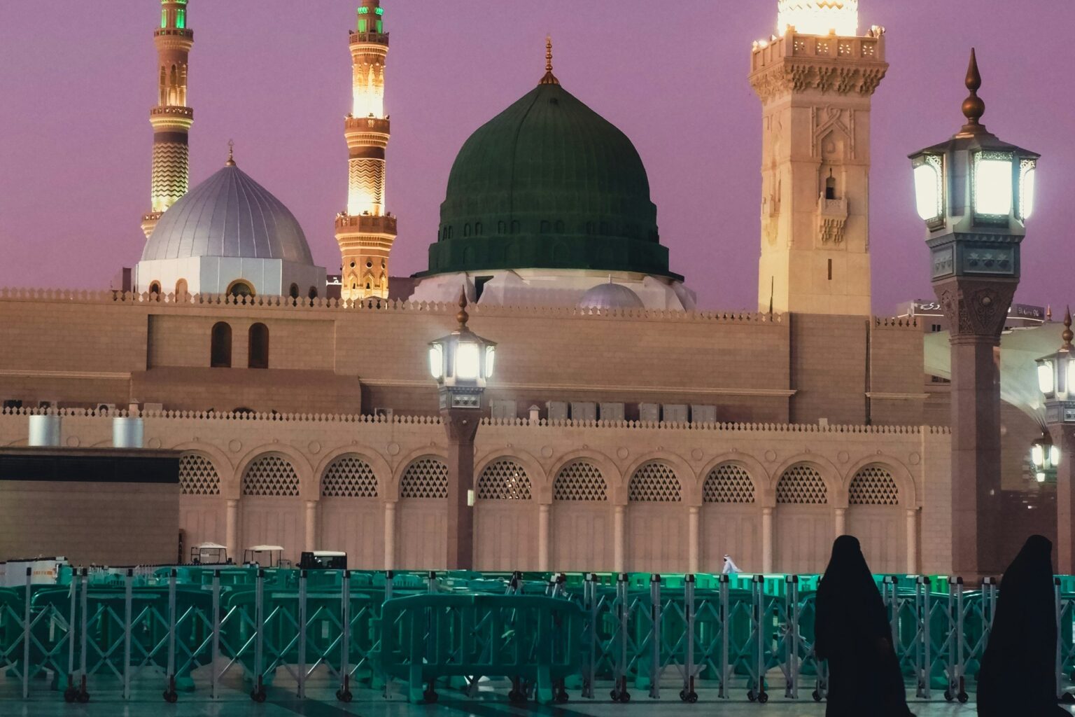 Dua jemaah wanita berjalan di perkarangan Masjid Nabawi waktu senja